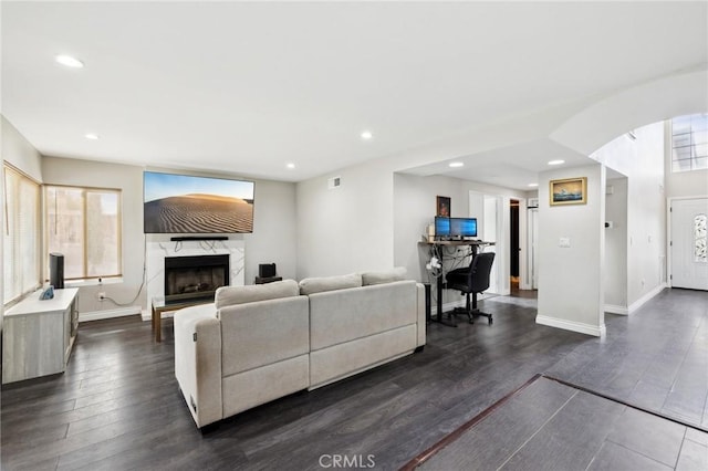 living room with dark wood-type flooring and a fireplace