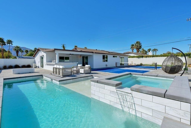 view of pool with an in ground hot tub and exterior kitchen