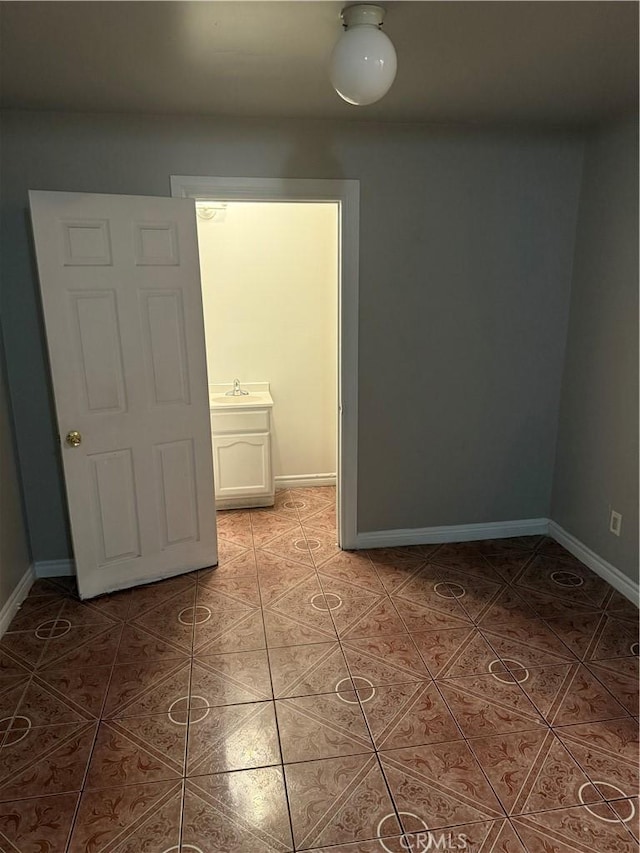 unfurnished room with sink and tile patterned floors