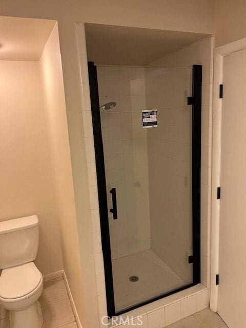 bathroom featuring toilet, tile patterned floors, and walk in shower