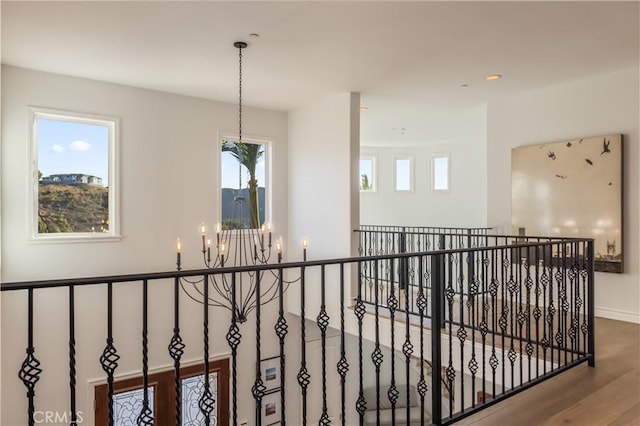 hall featuring hardwood / wood-style floors and a chandelier