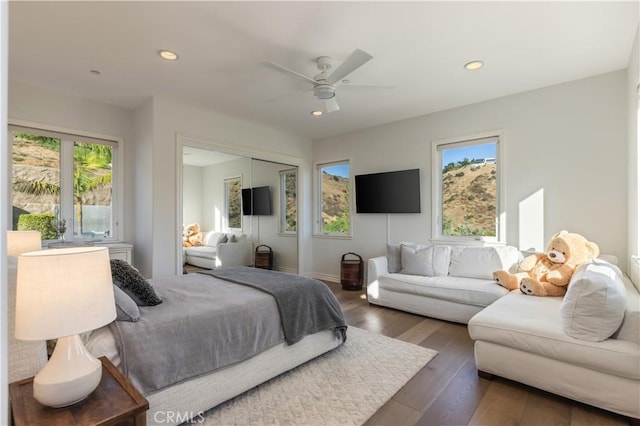 bedroom with dark hardwood / wood-style floors, ceiling fan, and a closet