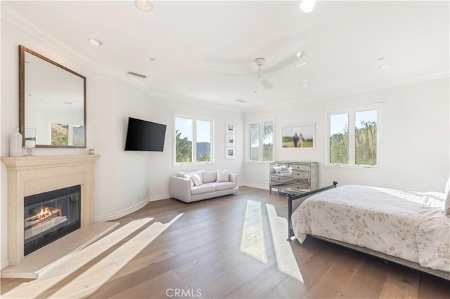 bedroom featuring multiple windows, ceiling fan, crown molding, and hardwood / wood-style flooring