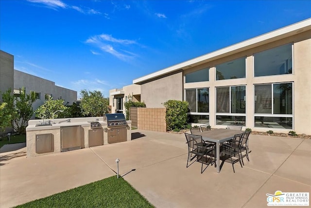 view of patio / terrace featuring exterior kitchen and a grill