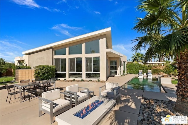 back of property featuring a patio area and an outdoor fire pit