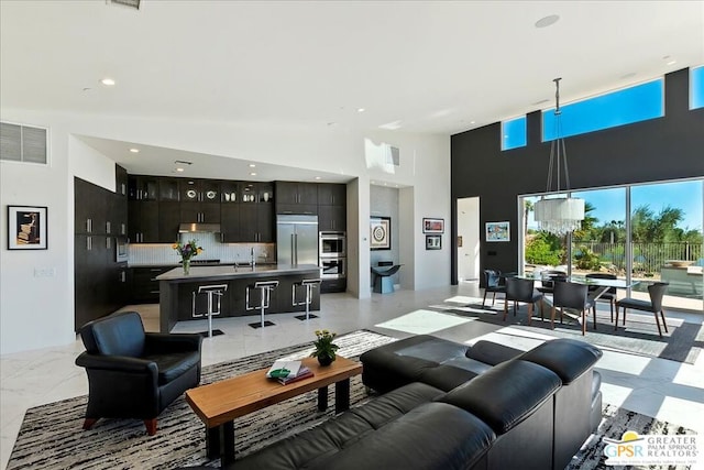 living room with a towering ceiling and sink