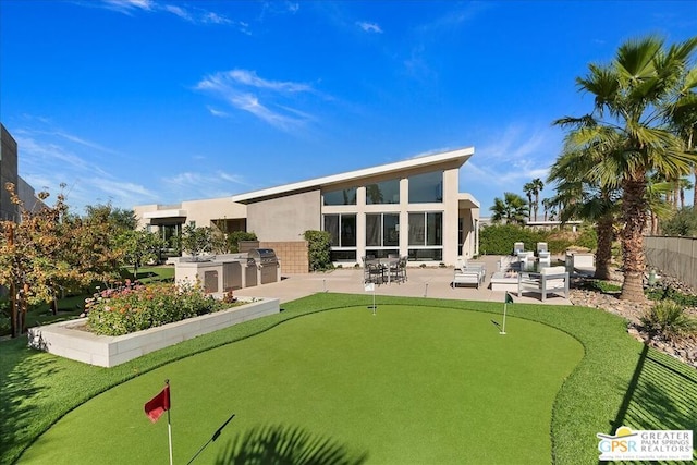 back of property with an outdoor kitchen and a patio