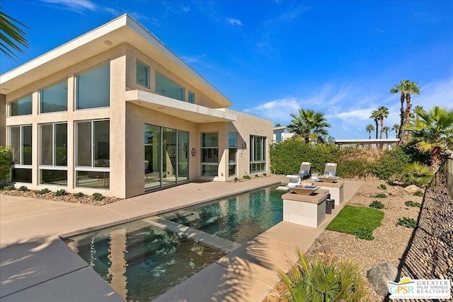 back of house with a fenced in pool and a patio area