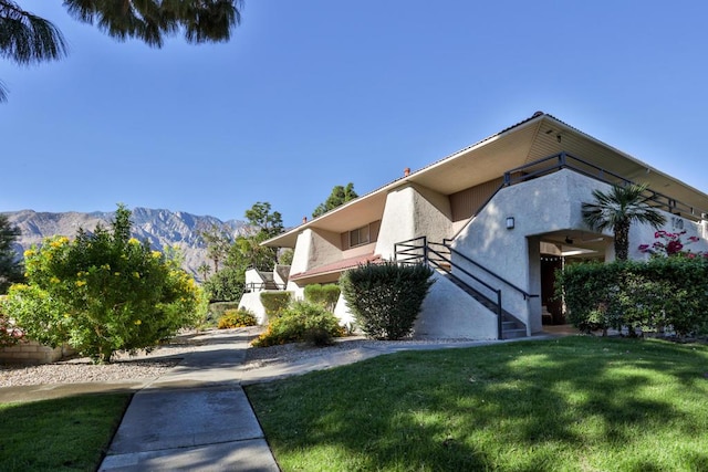 view of side of home featuring a mountain view and a yard