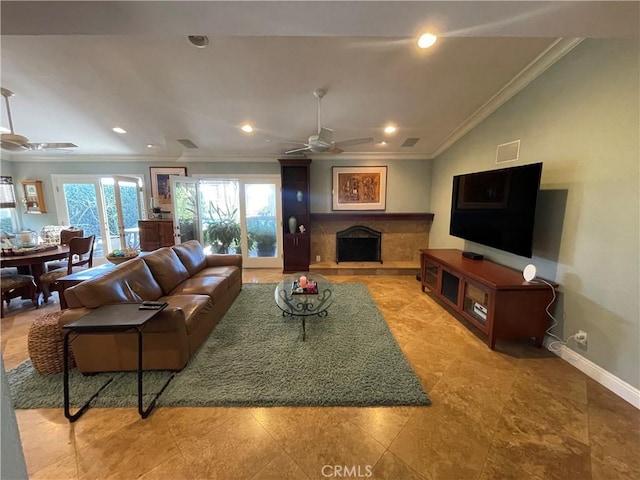 living room with ceiling fan, ornamental molding, and a tiled fireplace