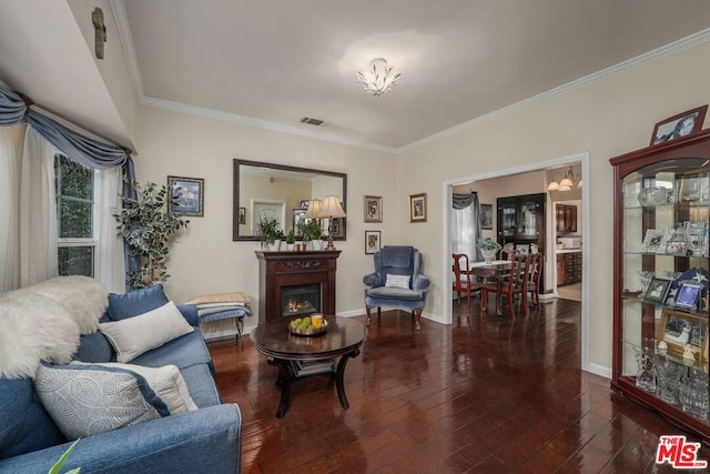 living room featuring a notable chandelier, dark hardwood / wood-style floors, and ornamental molding