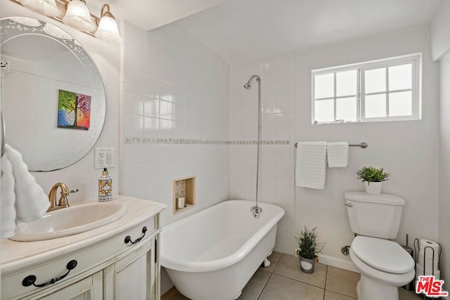 bathroom featuring a tub, tile patterned flooring, vanity, and toilet