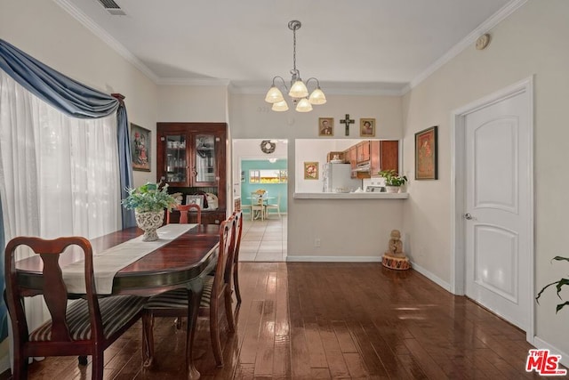 dining area featuring a chandelier, wood-type flooring, and crown molding