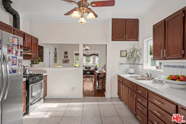 kitchen featuring stainless steel appliances, plenty of natural light, tile counters, and sink