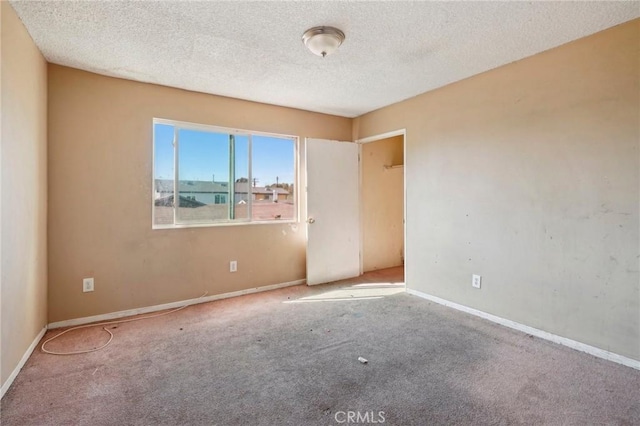 spare room with carpet and a textured ceiling