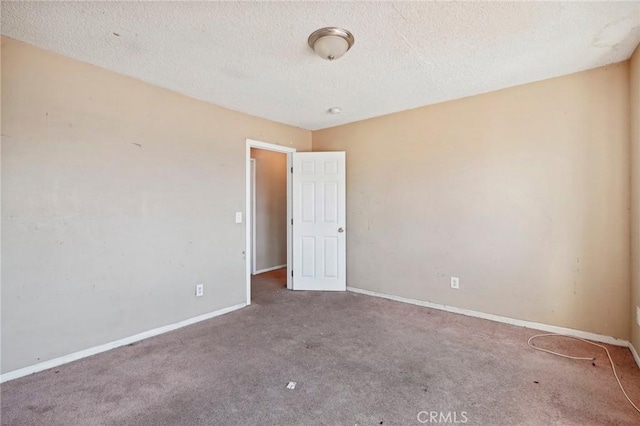 carpeted spare room featuring a textured ceiling