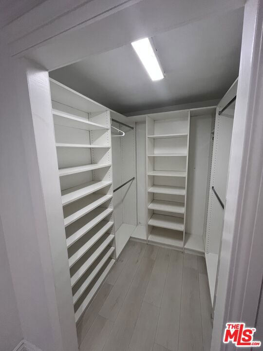 spacious closet featuring light hardwood / wood-style flooring