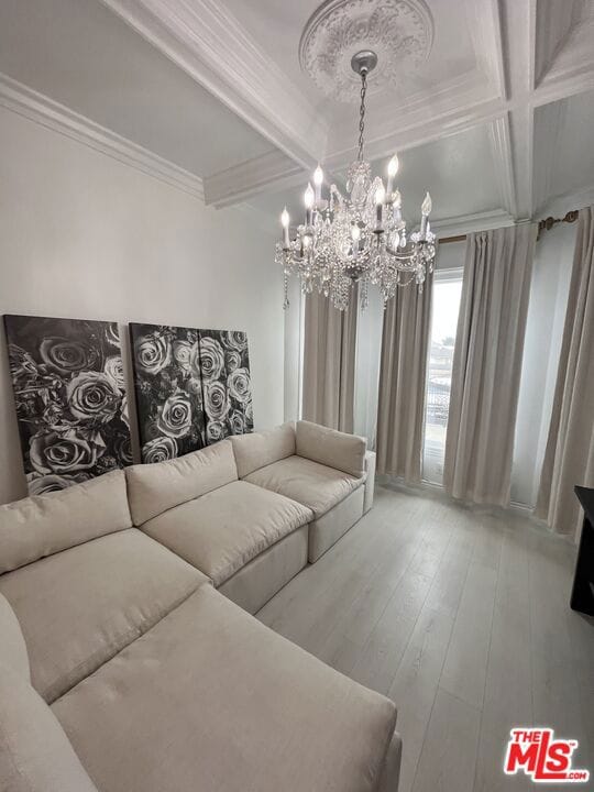 living room featuring a chandelier, beam ceiling, hardwood / wood-style flooring, and crown molding