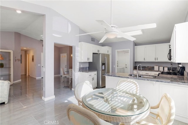 kitchen featuring kitchen peninsula, sink, dark stone countertops, white cabinetry, and stainless steel appliances