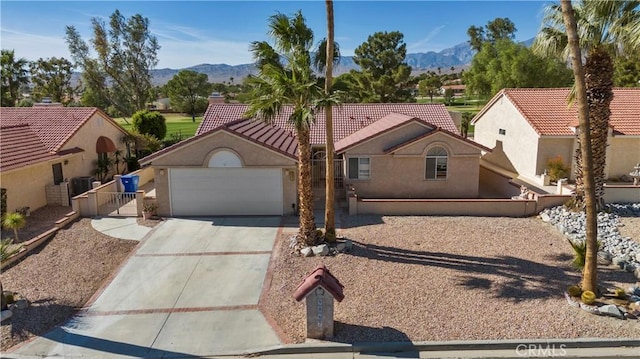 view of front of house with a mountain view, a garage, and central air condition unit