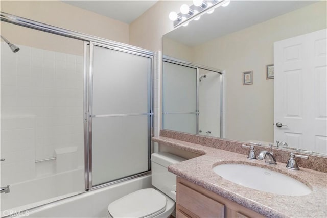 full bathroom featuring vanity, bath / shower combo with glass door, and toilet