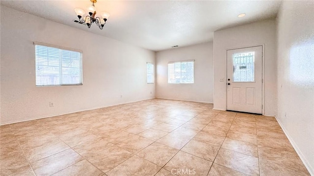 tiled foyer entrance with a chandelier