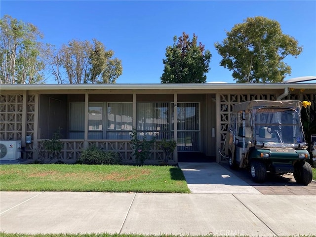 ranch-style home with ac unit and a front lawn