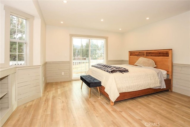 bedroom featuring multiple windows, light hardwood / wood-style flooring, and access to outside