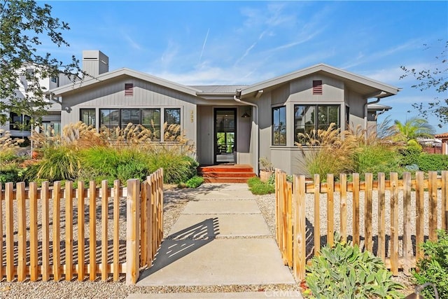 337 Holmwood Dr, Newport Beach, CA 92663 - view of front facade featuring a chimney, a gate, and a metal roof
