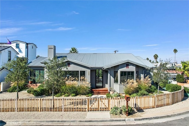 337 Holmwood Dr, Newport Beach, CA 92663 - view of front of home featuring a fenced front yard, a chimney, and a metal roof