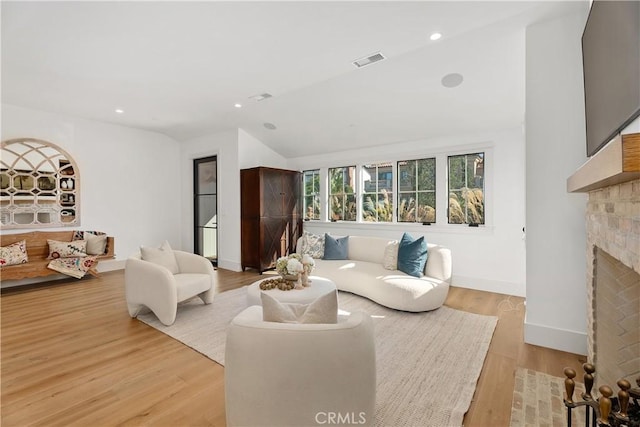 living room with vaulted ceiling and light wood-type flooring