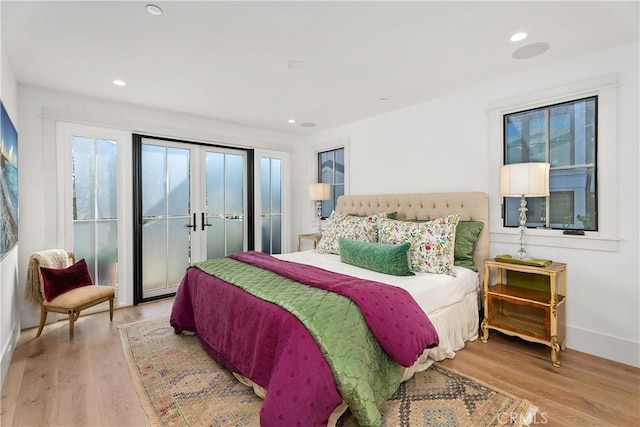 bedroom featuring french doors and light hardwood / wood-style flooring