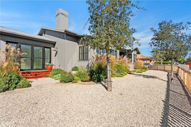 337 Holmwood Dr, Newport Beach, CA 92663 - back of property with french doors, a chimney, and entry steps