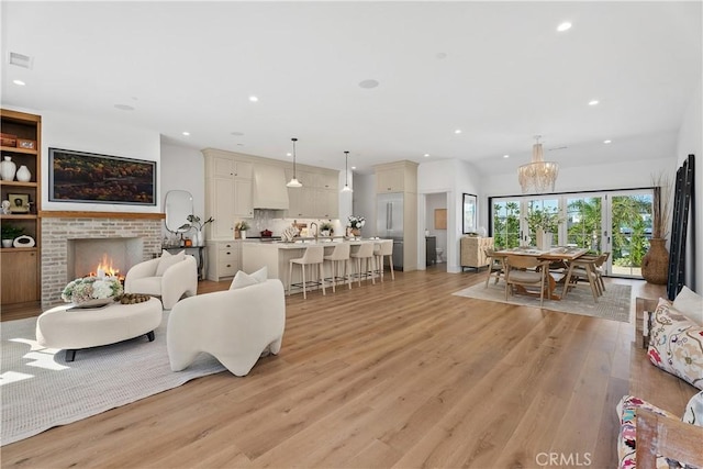 337 Holmwood Dr, Newport Beach, CA 92663 - living area with light wood-type flooring, recessed lighting, a chandelier, and a fireplace