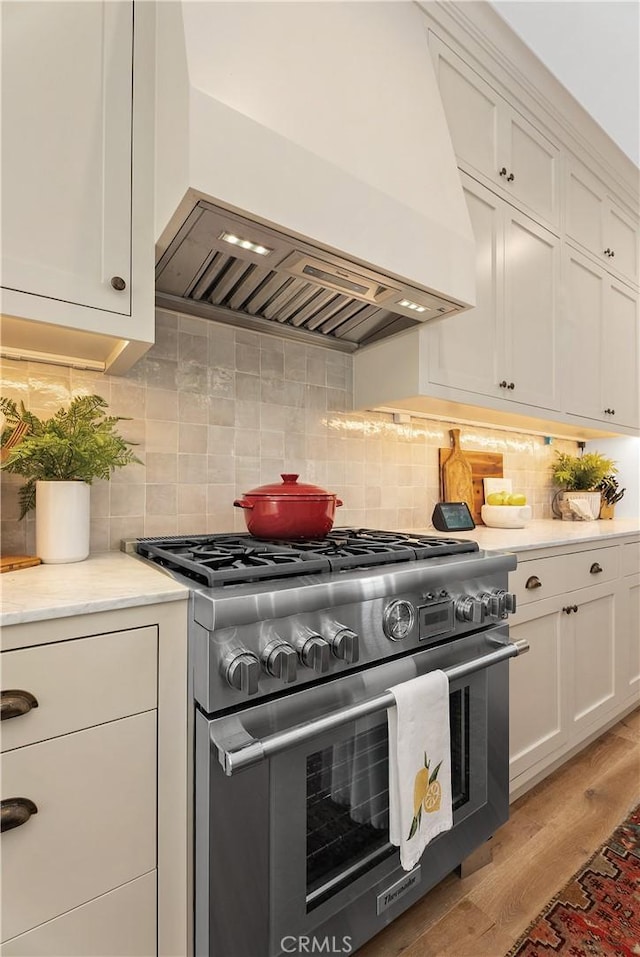 337 Holmwood Dr, Newport Beach, CA 92663 - kitchen featuring stainless steel range, custom range hood, white cabinets, and decorative backsplash