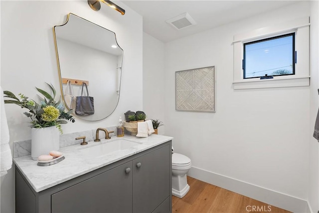 bathroom featuring hardwood / wood-style flooring, vanity, and toilet