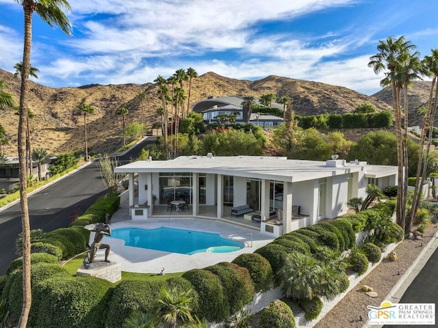 rear view of house featuring a mountain view and a patio