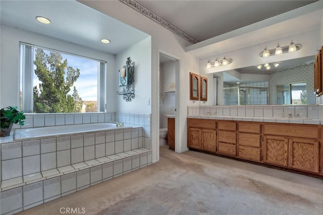 full bathroom featuring vanity, separate shower and tub, and toilet