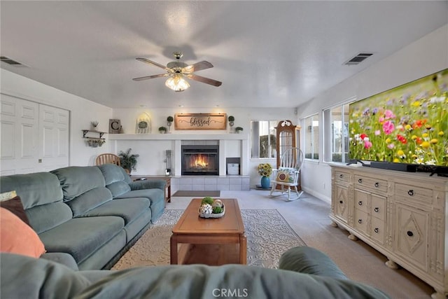 living room with light carpet, ceiling fan, and a fireplace