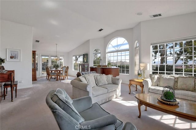 carpeted living room featuring lofted ceiling, a wealth of natural light, and an inviting chandelier