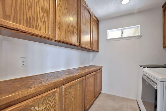 clothes washing area with cabinets, independent washer and dryer, a textured ceiling, and light colored carpet