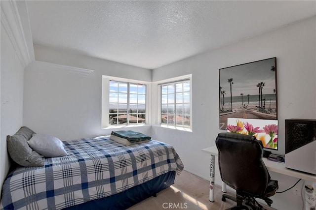 bedroom featuring a textured ceiling and light colored carpet