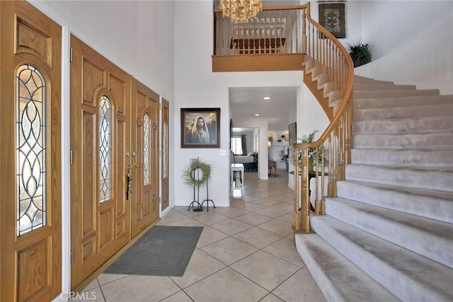 foyer with plenty of natural light, light tile patterned flooring, a high ceiling, and a chandelier