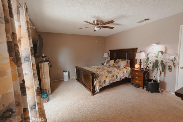 bedroom featuring light carpet, a textured ceiling, and ceiling fan