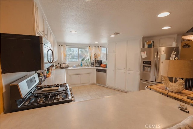 kitchen with stainless steel appliances, sink, a textured ceiling, and white cabinets