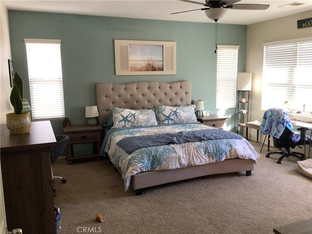 bedroom with carpet flooring, ceiling fan, and multiple windows