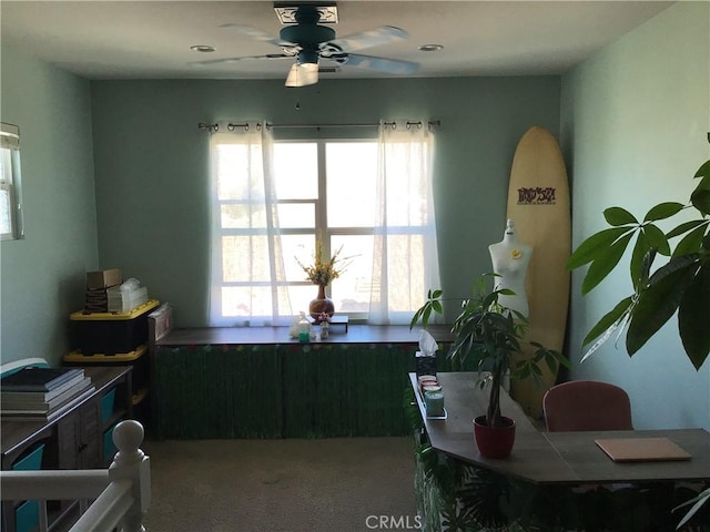 carpeted dining area with ceiling fan