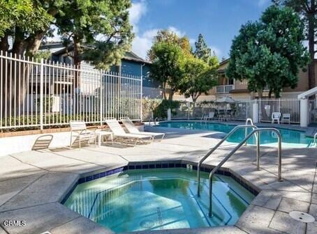 view of swimming pool with a patio area and a hot tub