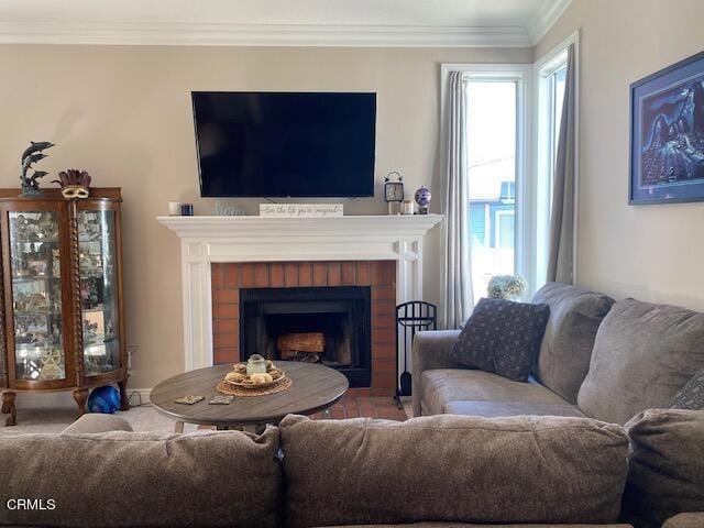 living room with crown molding, a wealth of natural light, and a brick fireplace