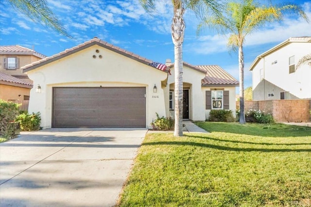 mediterranean / spanish-style house with a garage, a front yard, driveway, and stucco siding